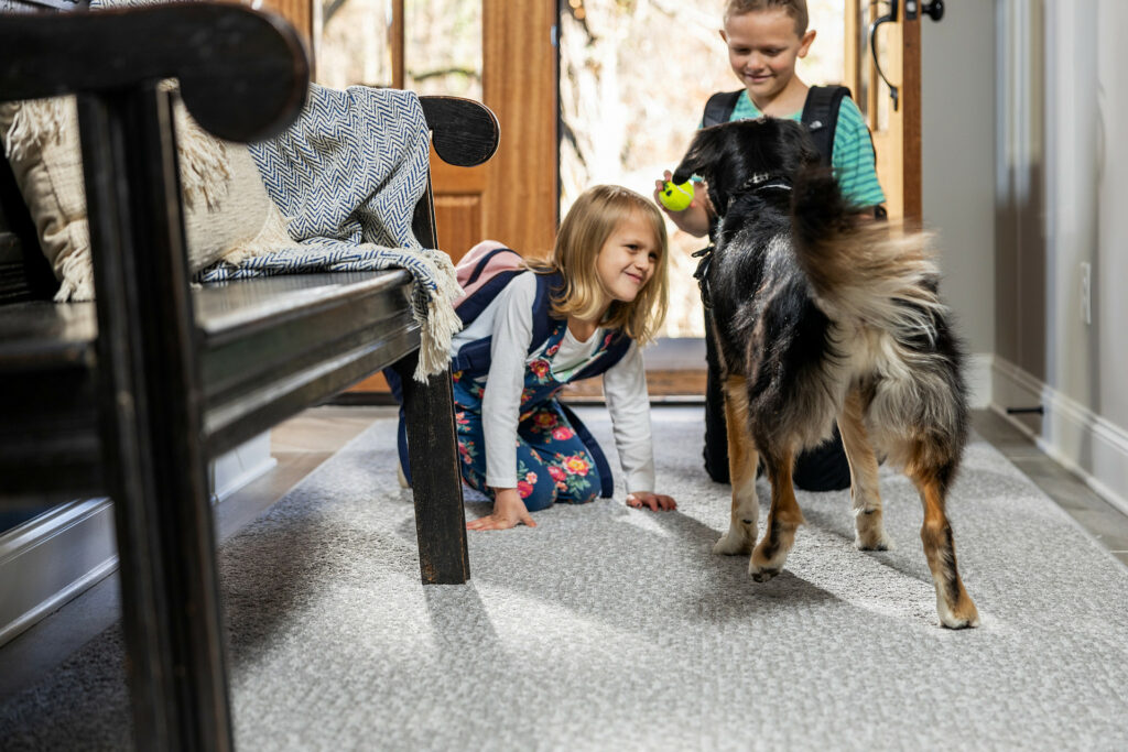 Kids plying with dog on carpet flooring | IQ Floors